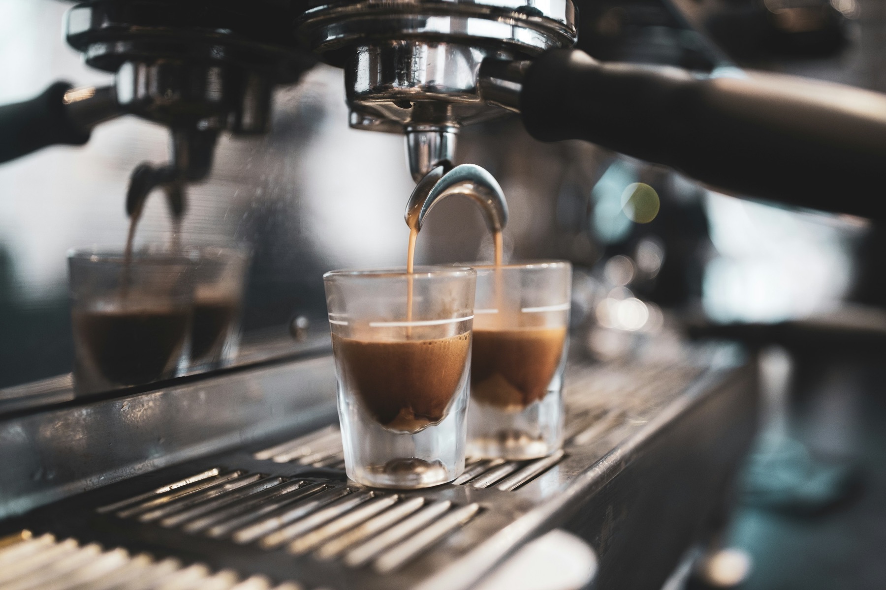 Espresso machine group head pouring into two glasses